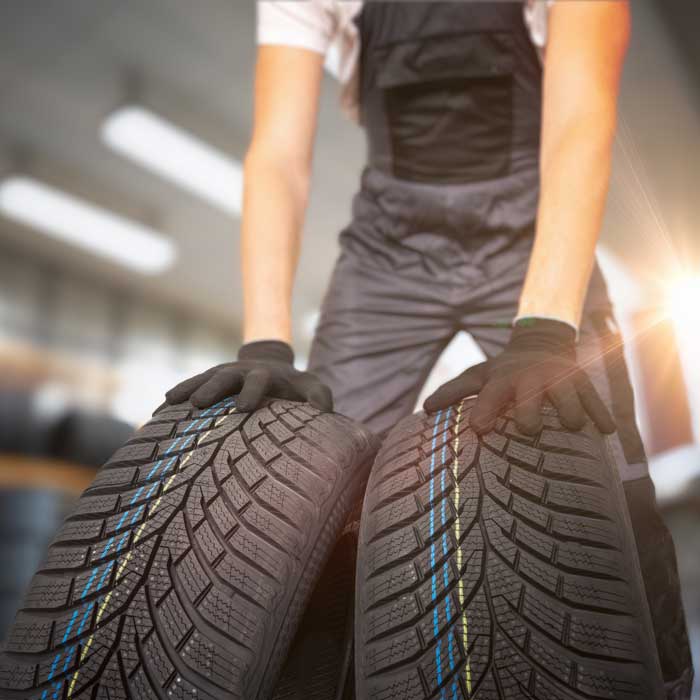 man wheeling new tires